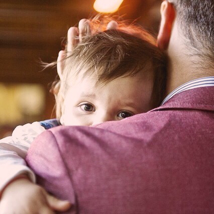 Ett barn i sin faders armar.